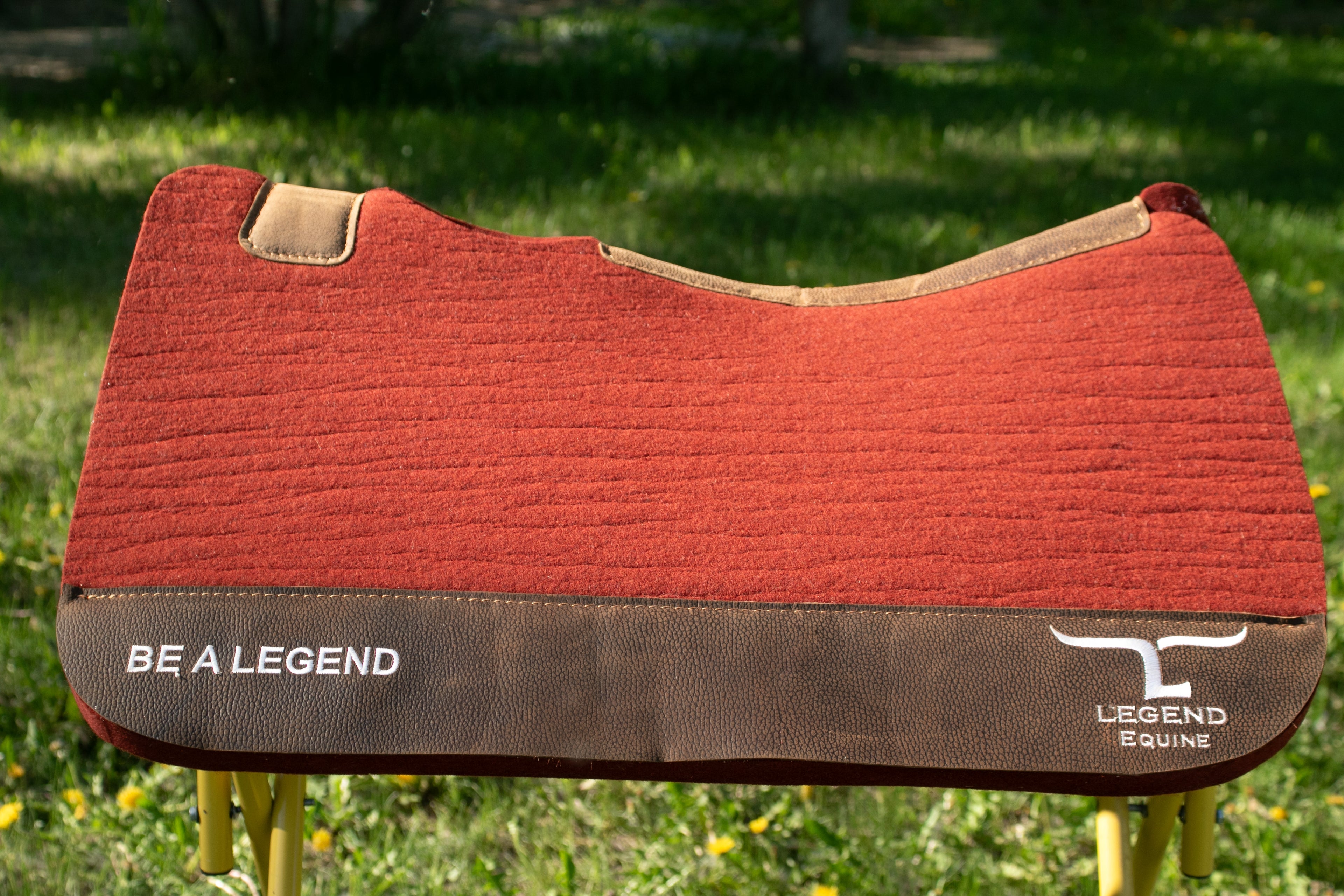 Rust and brown saddle pad with 'Be a Legend' branding